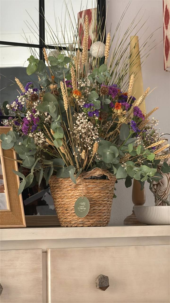 Arreglo de flores secas en cesta de fibras naturales, con eucalipto, espigas y flores moradas